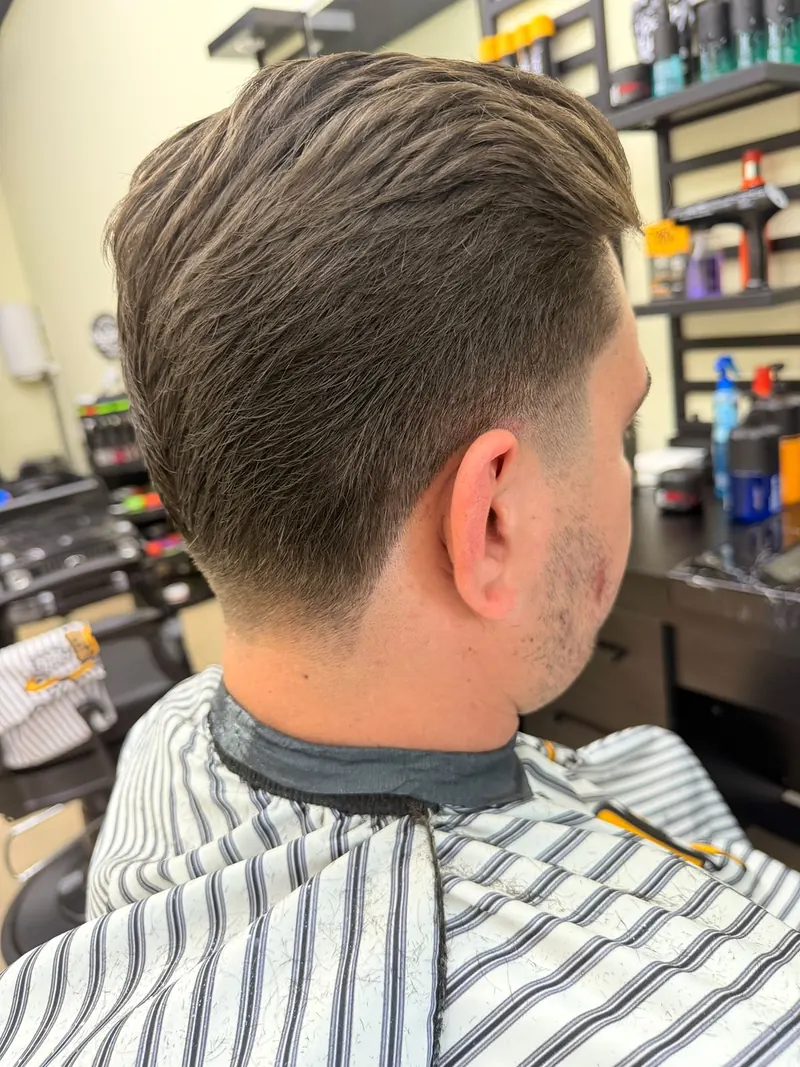 Taper fade met lang, naar achteren gestyled bovenhaar